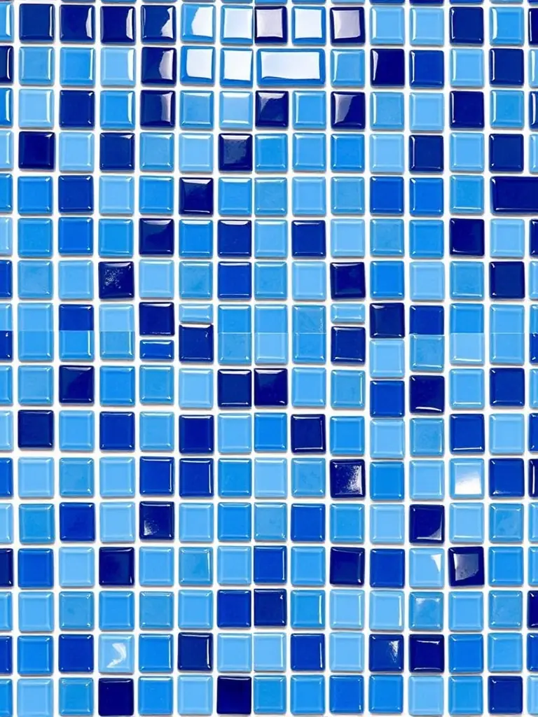 A high-resolution image of a set of small, mosaic-style ceramic tiles in varying shades of blue, arranged to create a vibrant and eye-catching backsplash in a kitchen.
